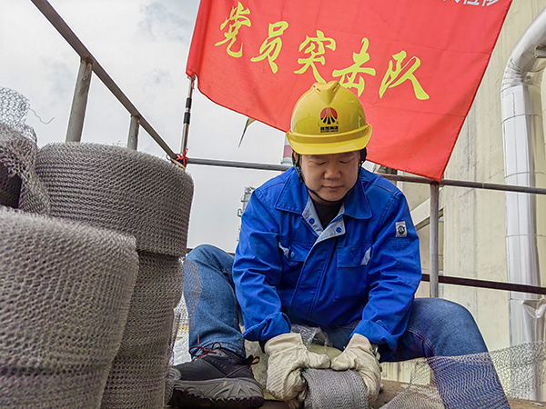 5月10日中午，在動力車間三期工藝除氧器平臺上，黨員突擊隊(duì)隊(duì)長李鑫正在纏繞新填料.jpg