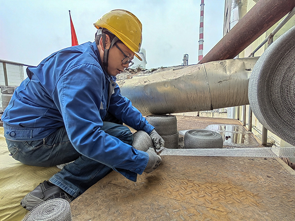5月10日中午，在動力車間三期工藝除氧器平臺上，黨員突擊隊(duì)隊(duì)員劉瑞斌正在纏繞新填料.jpg