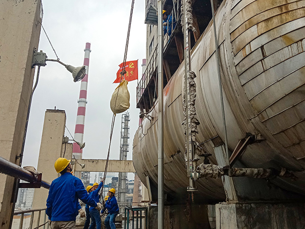 5月10日中午，在動力車間三期工藝除氧器地面，黨員突擊隊(duì)隊(duì)員用滑輪往工藝除氧器平臺運(yùn)送鋼絲網(wǎng)，用以纏繞新填料.jpg