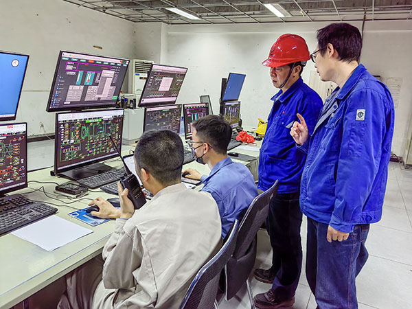 5月13日，動力車間三期鍋爐控制室，DCS改造工藝、儀表、電氣等部門聯(lián)合調(diào)試，車間主任姜軍虎與技術(shù)員畢加佳查看調(diào)試過程.jpg