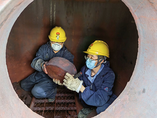 5月11日，動(dòng)力車(chē)間三期工藝除氧器內(nèi)部，黨員突擊隊(duì)隊(duì)員劉瑞斌和李震正在清理舊填料.jpg
