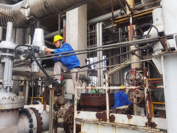 氣化爐上，柳曦、徐騰飛冒雨調(diào)試氣化爐電動閥.jpg