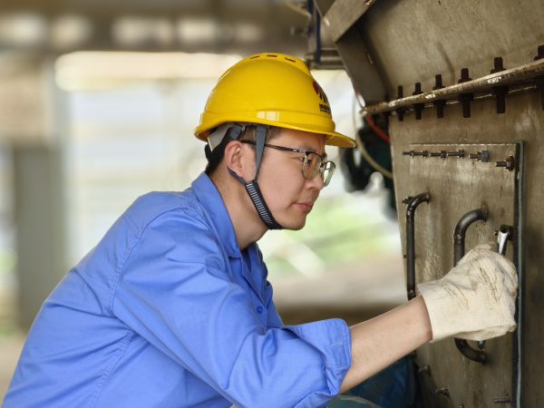 5月11日，尿素車間設(shè)備技術(shù)員馬強(qiáng)檢查設(shè)備螺栓是否松動(dòng).jpg